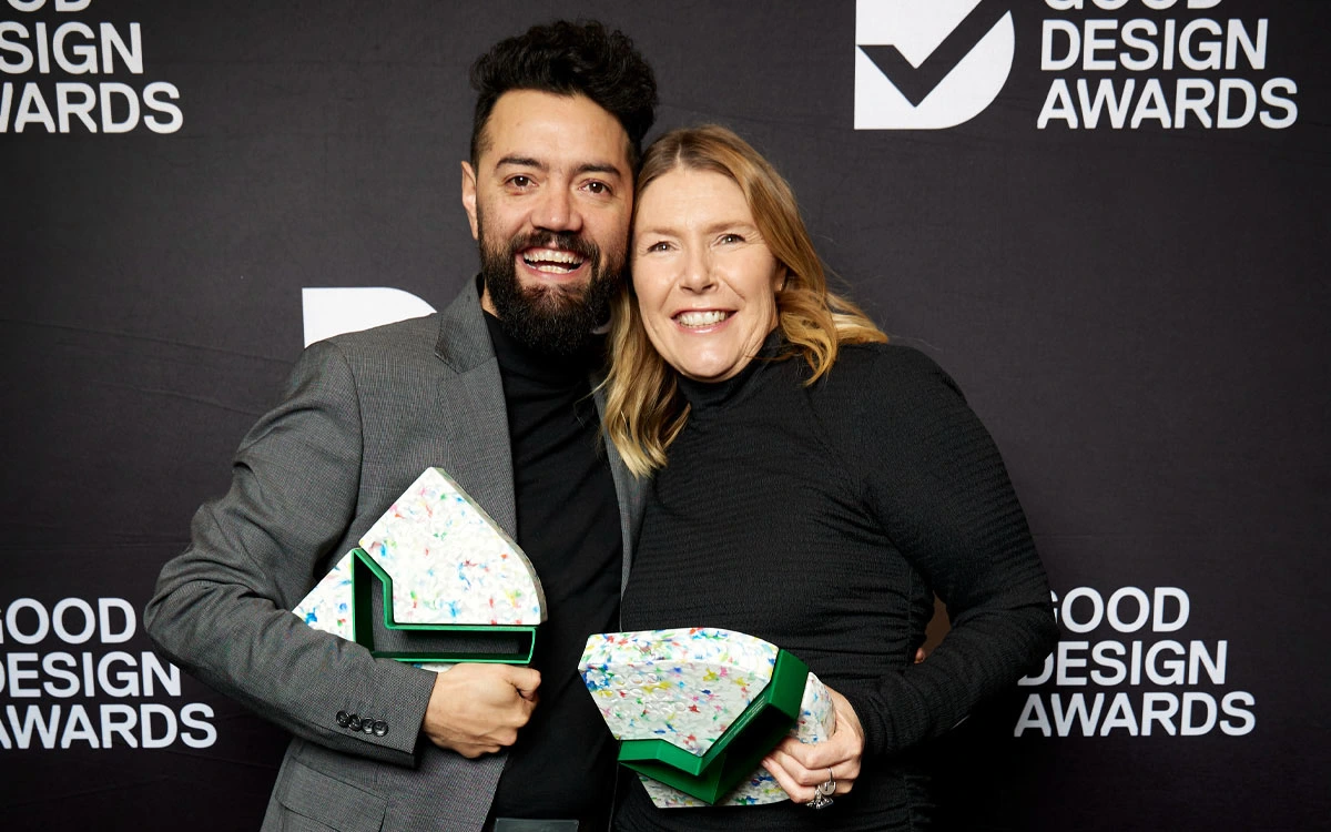 Hermann Ruiz and Jet Swain holding Good Design Award Trophies