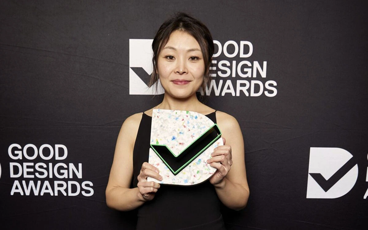 Mae Lu holding a Good Design Award Trophy